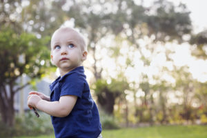 little boy in the grass, part of family portraits in Gainesville Fl