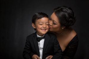 mother kissing son's cheek in studio