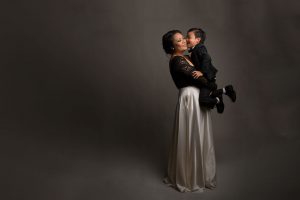 mother dressed up holding child in studio