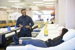 staff member explaining mattress highlights to a customer in mattress store